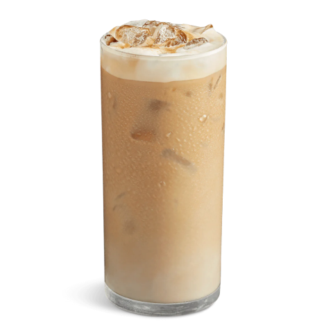 Ice cold Frappuccino in a tall transparent glass. The drink presented with a milky foam on top with a couple of ice cubes peeking out.